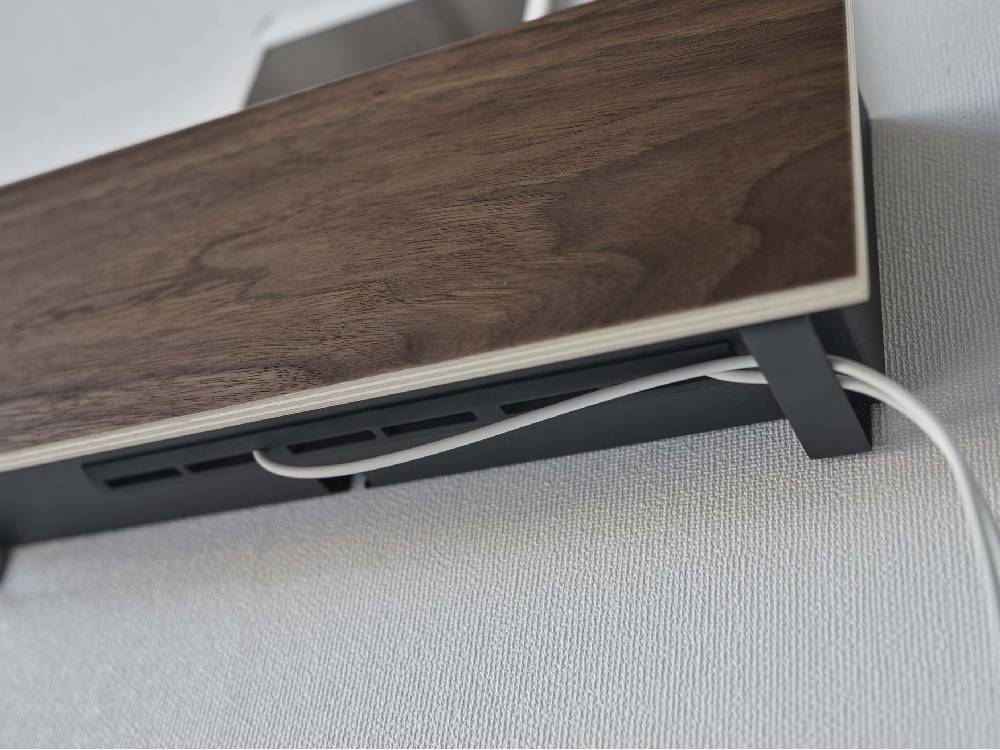 石こうボード壁対応のスチールと木材を組み合わせたデザインのタブレット＆リモコンホルダー。電気ケーブルが整理されている様子