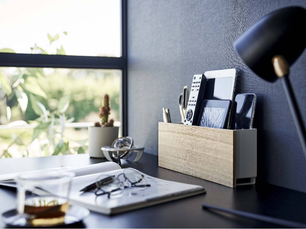 スチールと木材製のタブレット＆リモコンホルダーがオフィスデスク上に設置されている様子