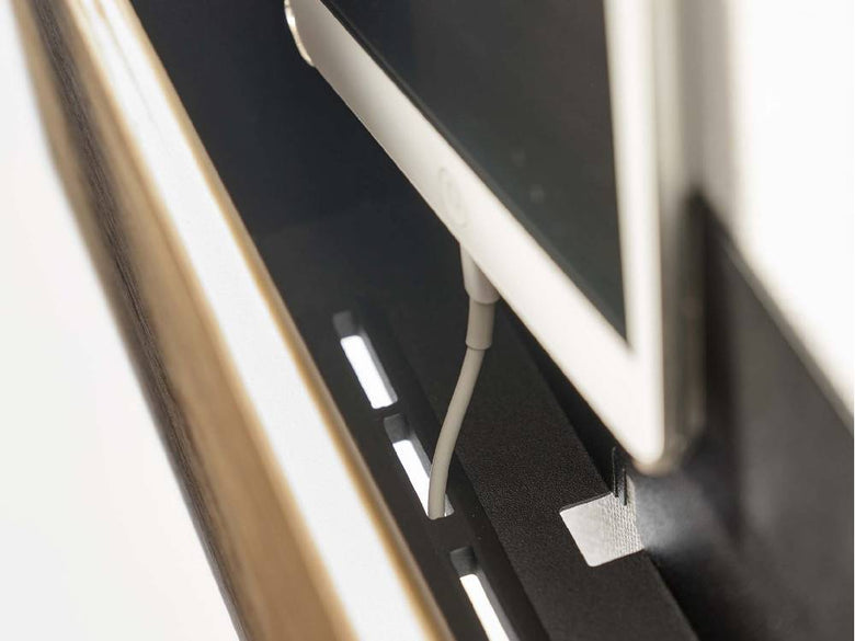 石こうボード壁に設置されたシルバー製【RIN/リン】タブレット＆リモコンホルダー。フラットパネルディスプレイと電子機器を収納