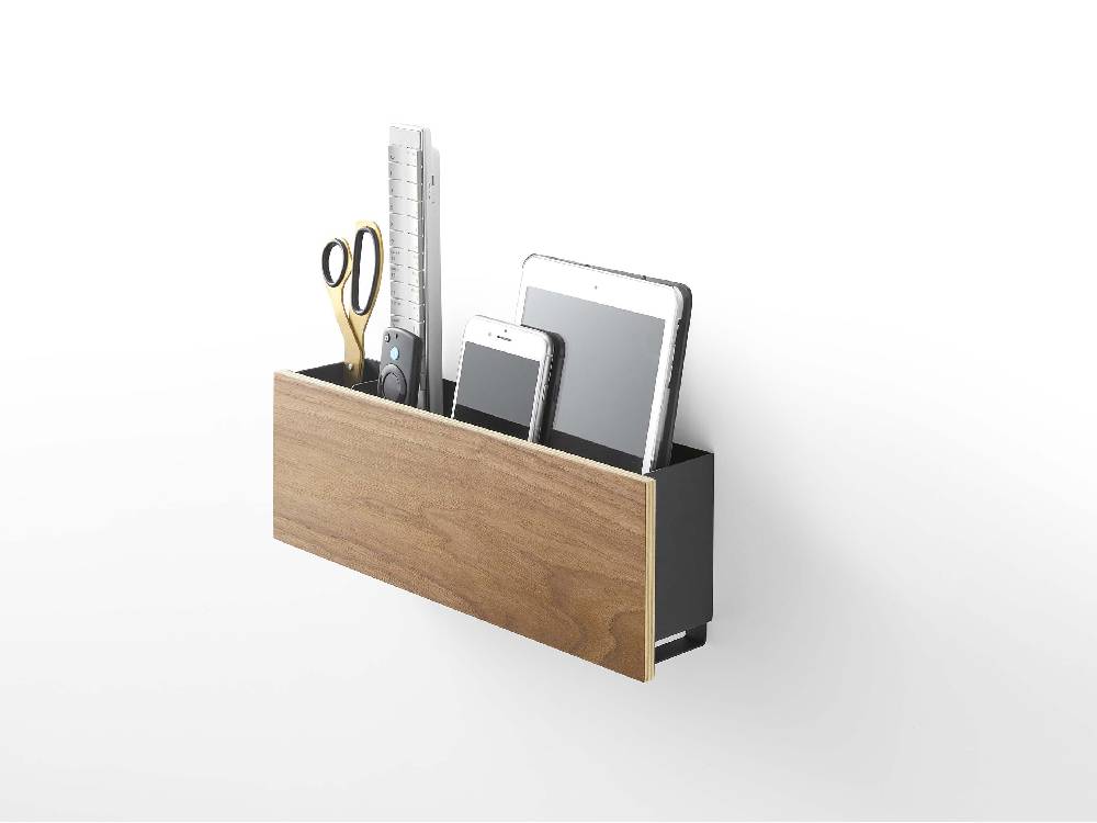 石こうボードに取り付けられたRINのタブレット＆リモコンホルダー、本体と充電ホルダーが整然と配置されたオフィス用品