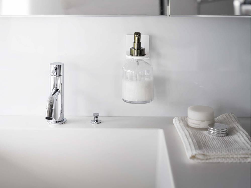 【MIST/ミスト】シルバー色のフィルムフックディスペンサーホルダー。ABS樹脂製ホルダーにソープディスペンサーが取り付けられ、バスルームの洗面台に設置されている様子。