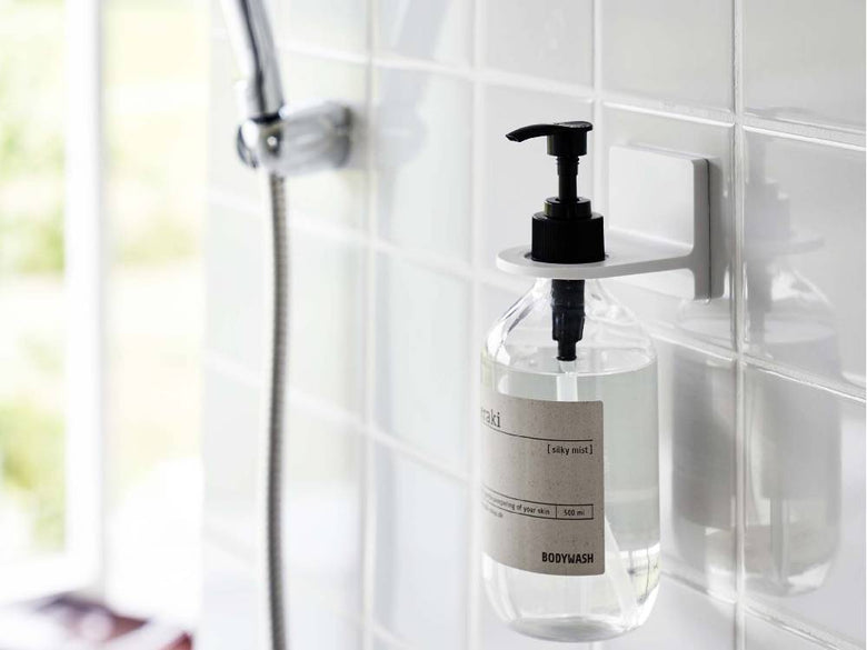 シンクに設置されたプラスチック製ソープディスペンサーとフィルムフックディスペンサーホルダー