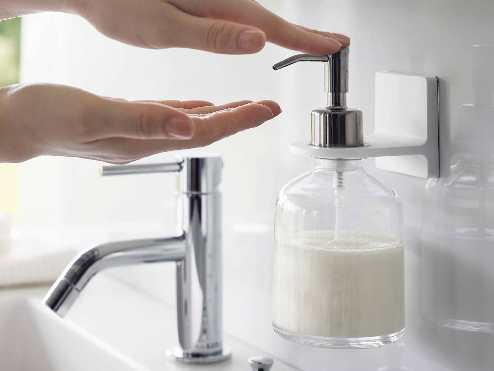 ミストのフィルムフックディスペンサーホルダーが浴室のカウンタートップに設置され、ソープディスペンサーと共に配置されている様子