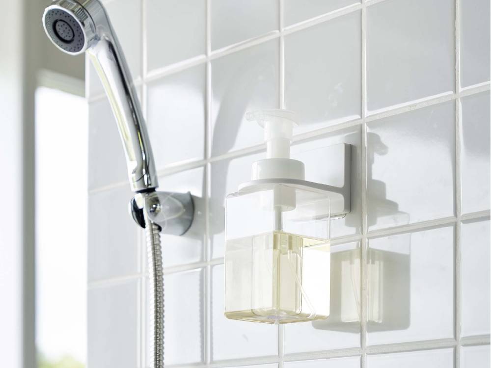 浴室の壁に取り付けられた【MIST/ミスト】フィルムフックディスペンサーホルダー 泡タイプ。蛇口やシャワーヘッドなどの配管器具と共に配置されています。