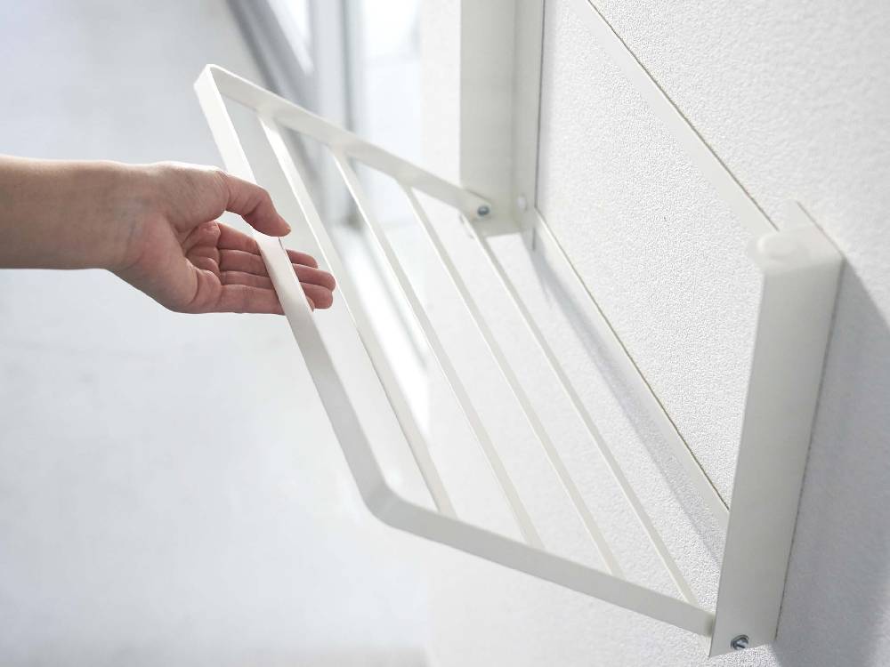 清潔な石こうボード壁に取り付けられたタワー型折り畳み棚