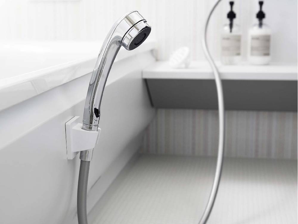 バスルームに取り付けられたシルバー製【MIST/ミスト】フィルムフックシャワーホルダー。蛇口や配管と共に配置されている