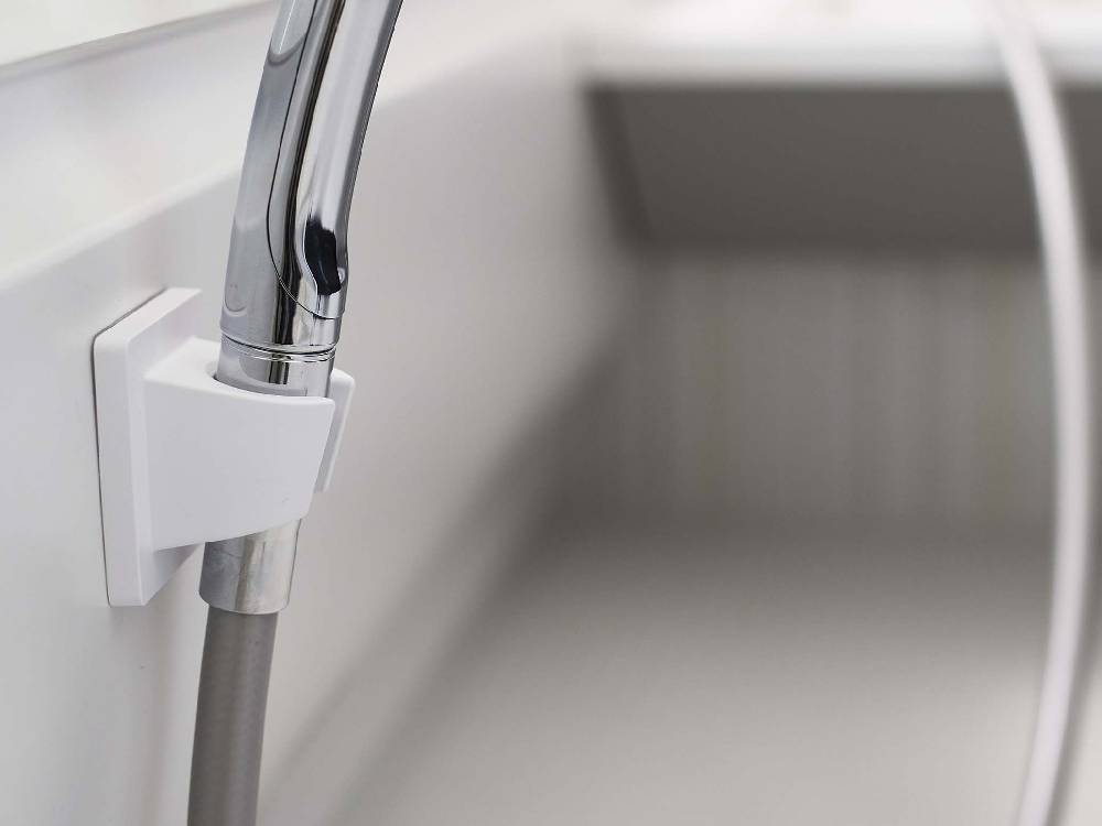 銀色のミストフィルムフックシャワーホルダーがバスルームの壁に取り付けられている様子