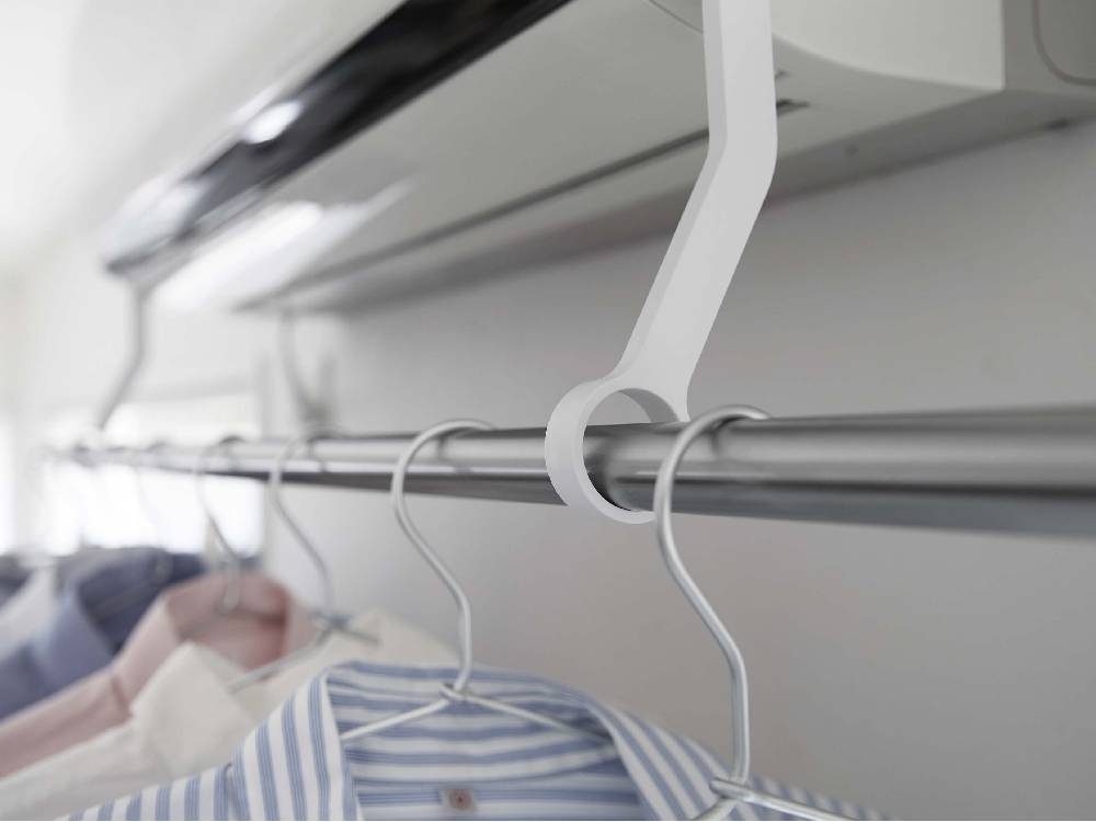 エアコンに取り付けられた【tower/タワー】フィルムフック物干しポールに掛かった洋服ハンガー