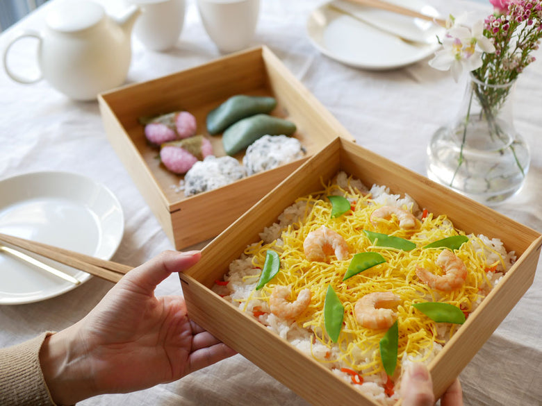 公長斎小菅の二段重箱に盛られたご飯と彩り豊かな料理が美しく配置されたお弁当