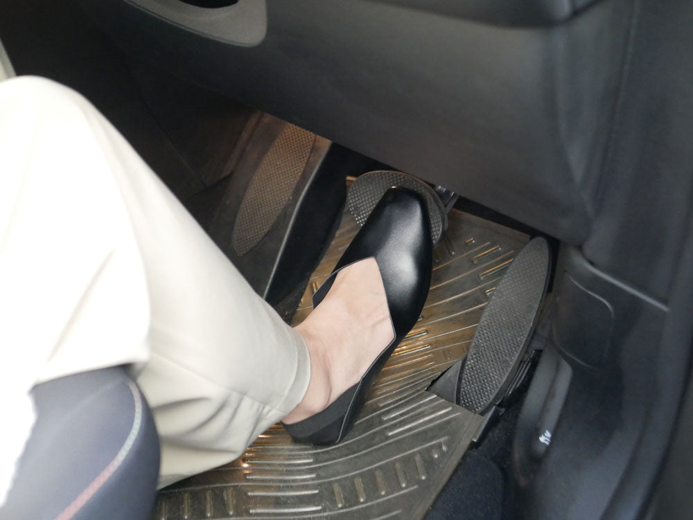 合成皮革とゴム底を使用したHinata Lifeの携帯スリッポンが車のシートカバーの上に置かれている様子