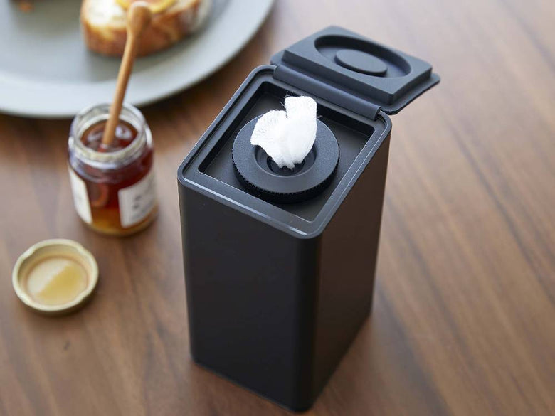 タワー型ロールウェットティッシュケース（約W8×D9×H17cm）がテーブルに置かれている写真