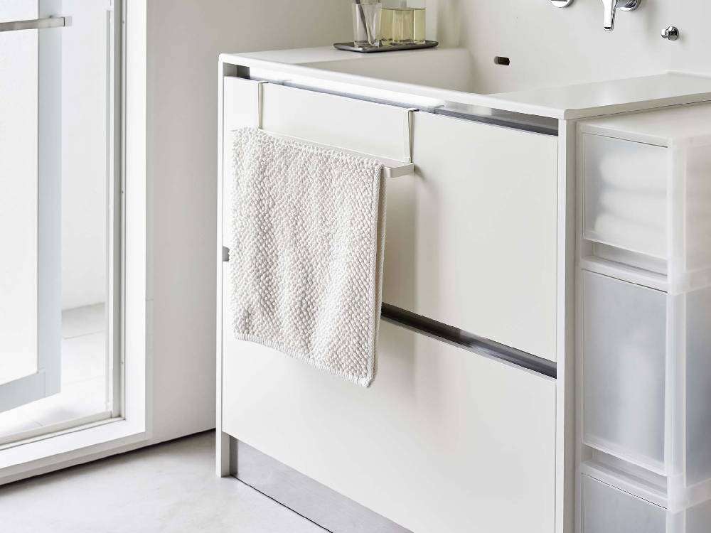 洗面下キャビネットに取り付けられた銀色のスチール製バスマットとタオルハンガー