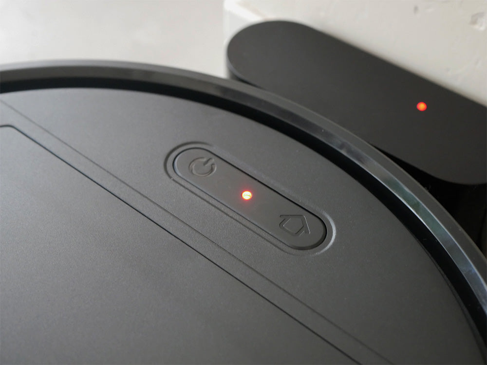 黒色の自動充電式ロボットクリーナー「AiMY/エイミー」と充電台が並んでいる様子