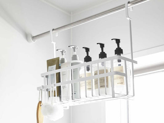 スチール製のタワー型引っ掛けバスルームバスケットが壁に掛けられ、周囲に棚やキッチン用品が配置されたバスルームの様子