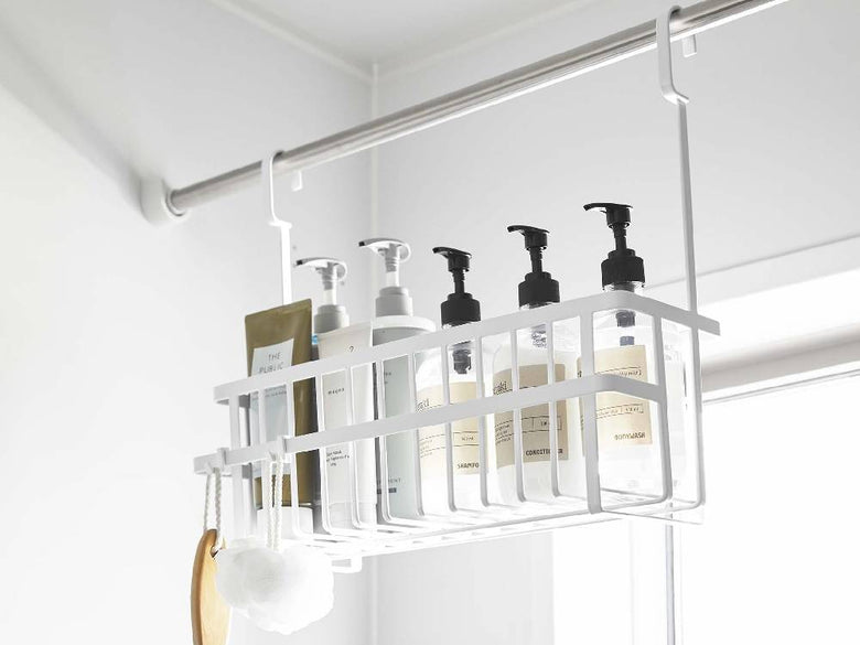 スチール製のタワー型引っ掛けバスルームバスケットが壁に掛けられ、周囲に棚やキッチン用品が配置されたバスルームの様子