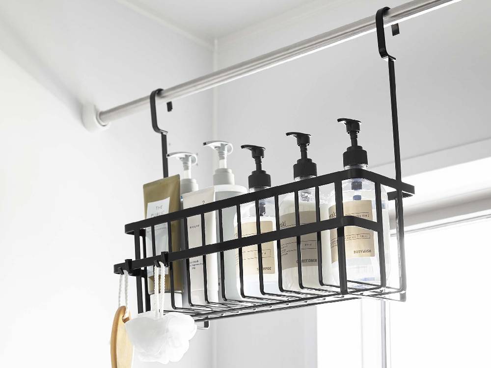 キッチンの棚に掛けられた【tower/タワー】引っ掛けバスルームバスケット ワイド。天井の照明とパイプが背景に見える