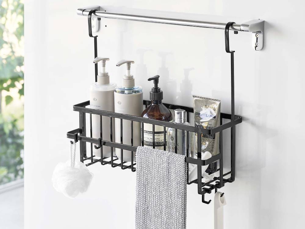 スチール製の引っ掛けバスルームバスケットが浴室のタオルバーに掛けられ、シンクや蛇口、歯ブラシホルダーなどのバス用品が整然と配置されている様子
