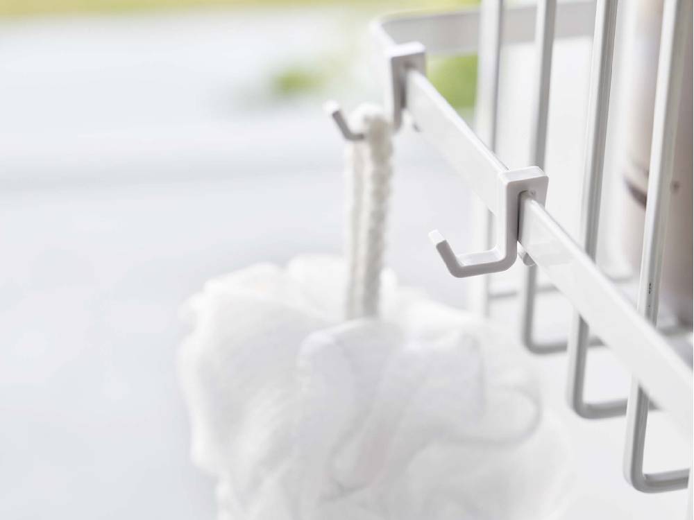 スチール製の「tower」ワイド引っ掛けバスルームバスケットが浴室のタオルバーに取り付けられている様子