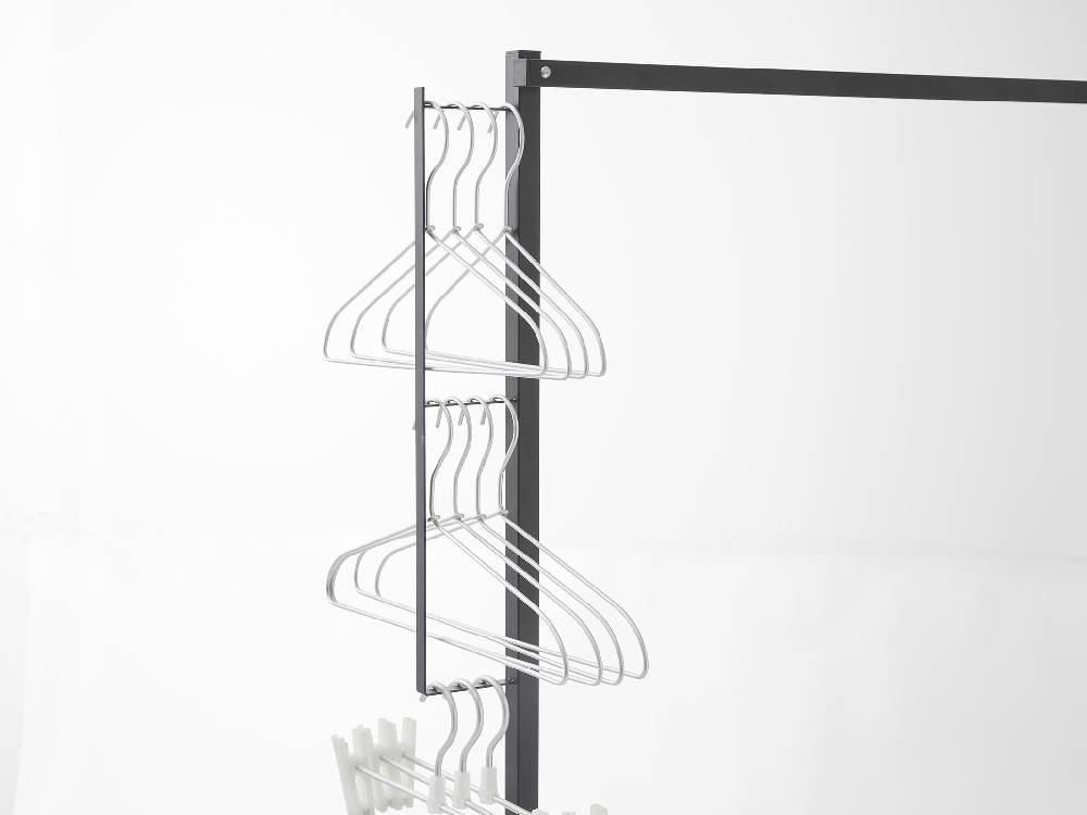 スチール製タワー型折り畳み室内物干しに衣類が掛けられ、棚が配置されている様子
