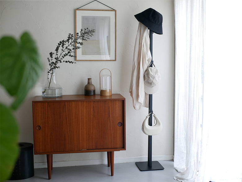 家具や観葉植物と調和した室内インテリアに配置されたスチール製の折り畳み式タワー物干し