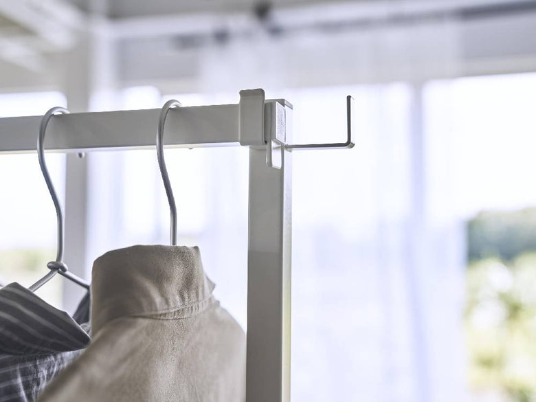 クローゼット内に設置されたアルミ製の折り畳み室内物干し「tower」で、複数のハンガーに衣類がかかっている