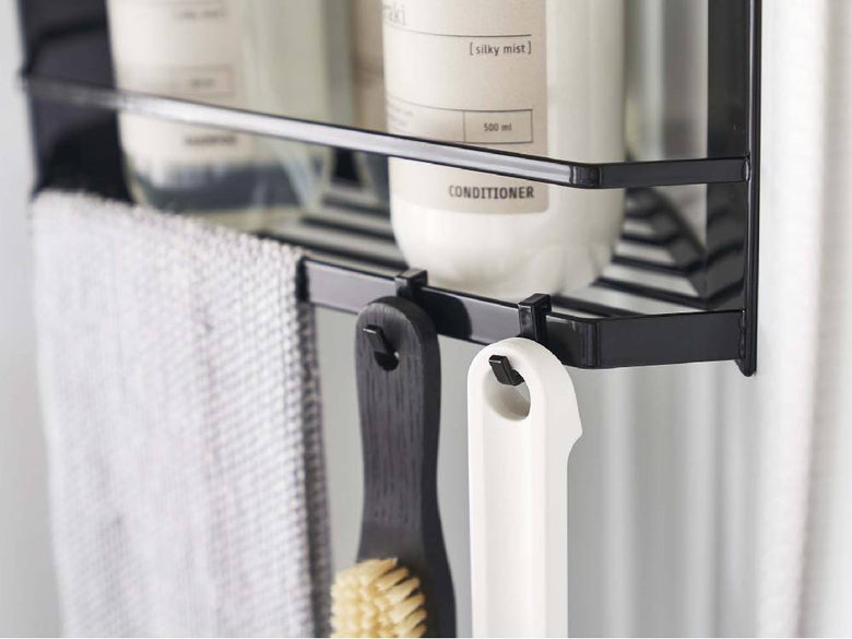 シルバー製の2段マグネットバスルームコーナーラックにタオルや衣類が掛けられている様子