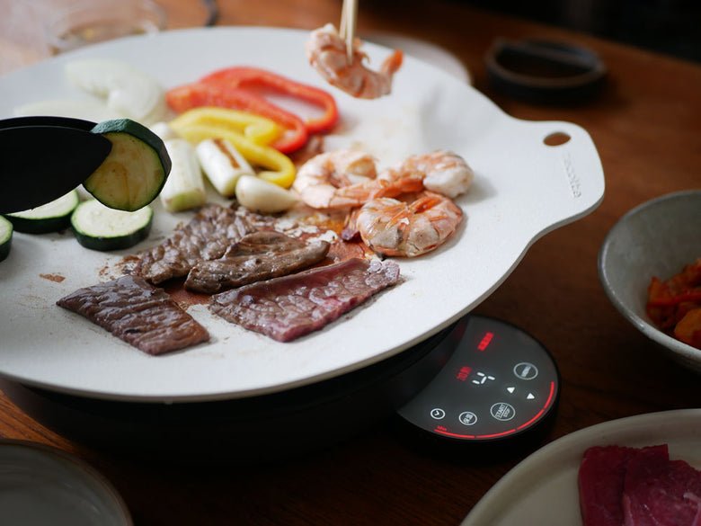 レコルト卓上IHクッキンググリドルで肉や野菜を調理している様子