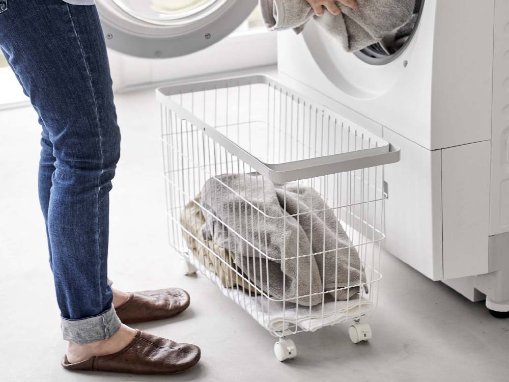 キャスター付きスチール製ワイド＆ローランドリーバスケットが洗濯室に置かれている様子