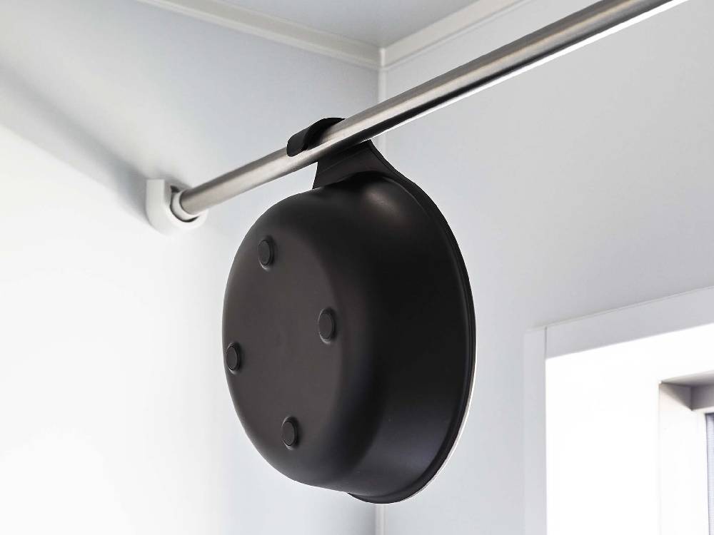 スチール壁にマグネットで取り付けられた【MIST/ミスト】マグネット&引っ掛け湯おけ。銀色とアルミニウム色の金属パーツを使用したポリプロピレン製のホワイトハードウェア。