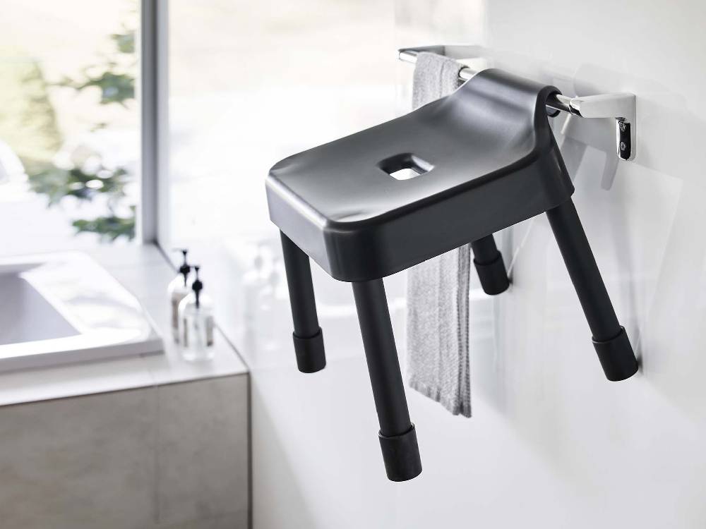 バスルームに設置されたシルバーとアルミニウム製の【MIST/ミスト】引っ掛け風呂イス SH25とシンク、蛇口が配置された様子