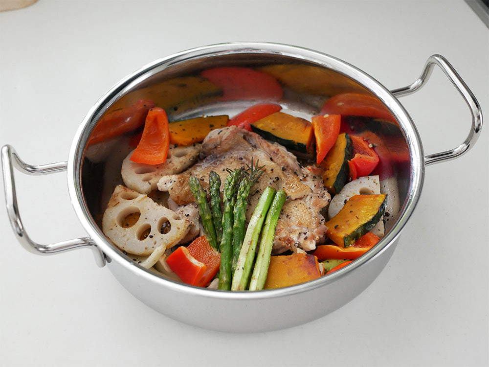 15年保証の日本製ジオプロダクト片手鍋16cm、フタ付きで肉と野菜が調理中のキッチン用品