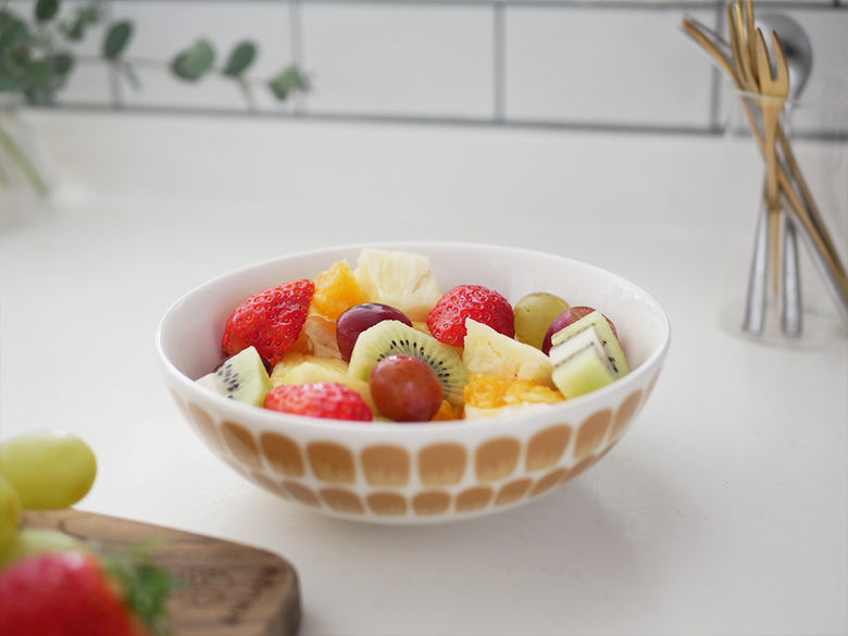 アラビアの24hトゥオキオボウルに盛られたイチゴとフルーツサラダがテーブルウェアと共に配置された様子