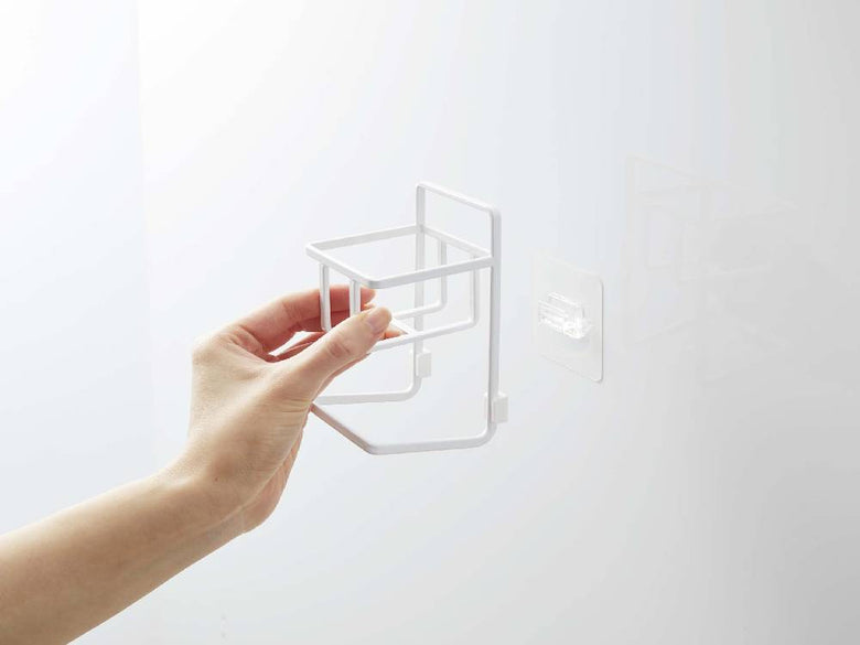 タワー フィルムフックスポンジ＆ボトルホルダーが壁に取り付けられ、ボトルやスポンジを掛けている家庭用収納用品の写真