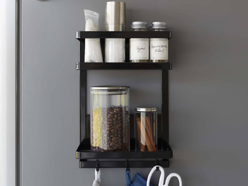 キッチンのスチール製2段マグネットラックに食器やボトルが整然と並んでいる様子