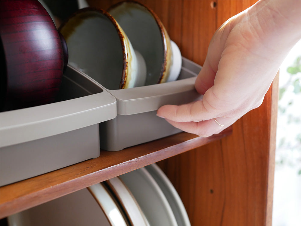 木製の棚にリッチェルのディッシュスタンドが置かれ、食器が整然と並べられているキッチンの様子