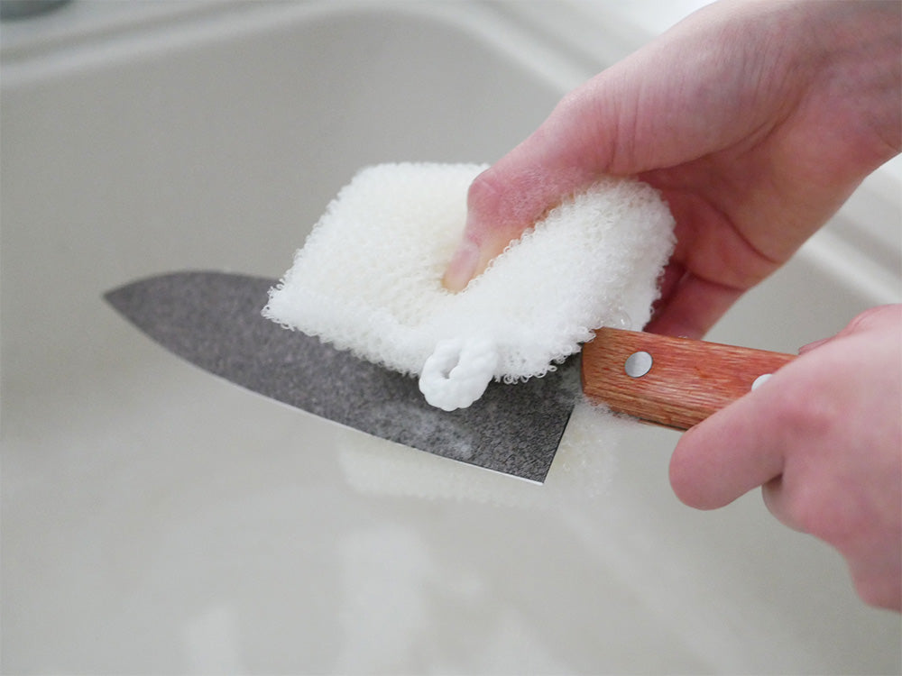 手と指で協和工業のスーパーストーンバリア包丁を使用し、切り板の上で調理している様子