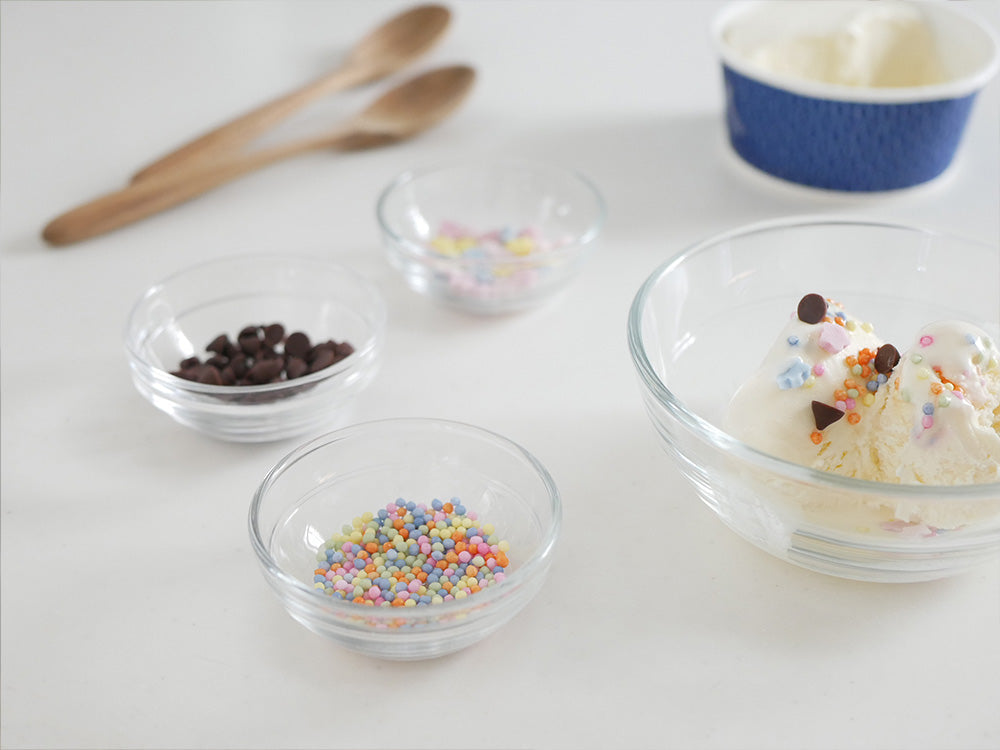 全面物理強化ガラス製のデュラレックス リスボウルにデザートが盛られ、スプーンが添えられた食卓用のテーブルウェア