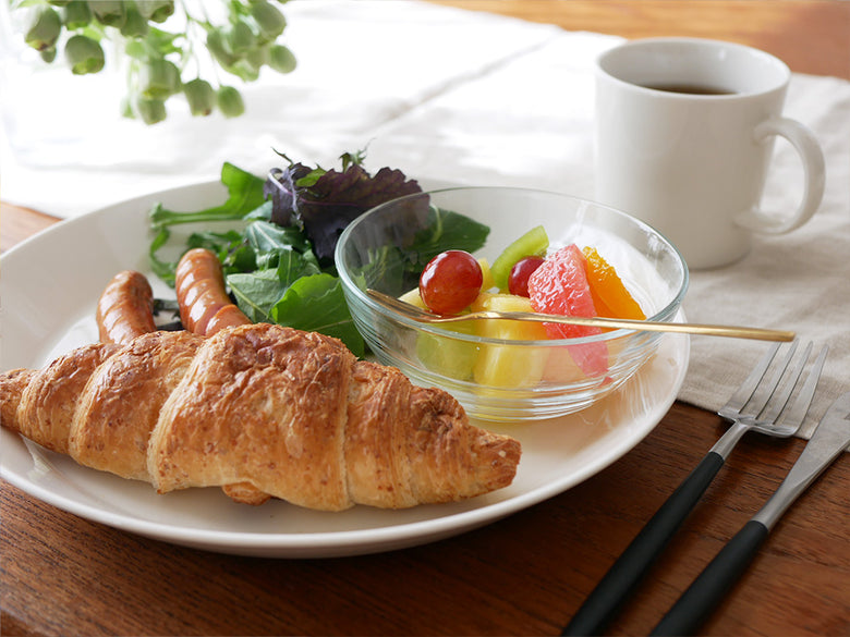 デュラレックス製リスボウルにクロワッサンと果物が盛られた朝食テーブル