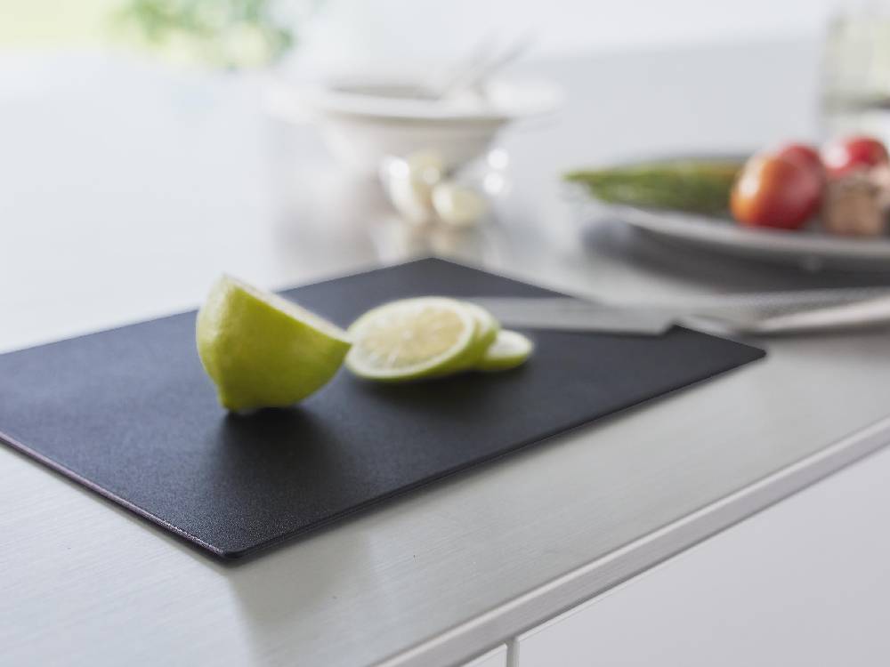抗菌シートまな板の上にカトラリーや柑橘類が並べられたキッチン用品の写真