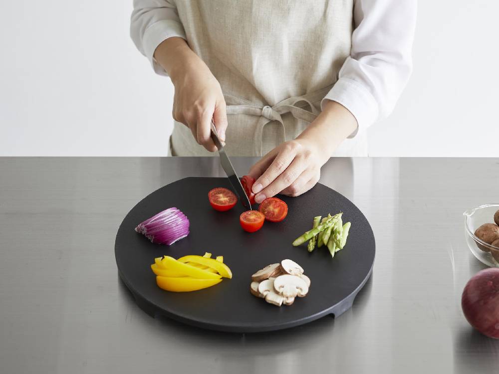 食洗機対応のマグネット抗菌まな板に新鮮な野菜や果物が並べられたキッチンの調理風景