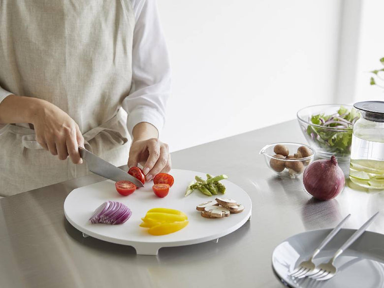 食洗機対応のマグネット抗菌ラウンドまな板の上に新鮮な野菜や果物が並べられているキッチンの様子