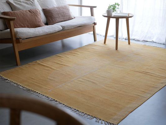 アデペシュ製MANEREコットンラグが木製フローリングの上に敷かれている様子。自然素材で織られたウーブンファブリックが特徴的です。