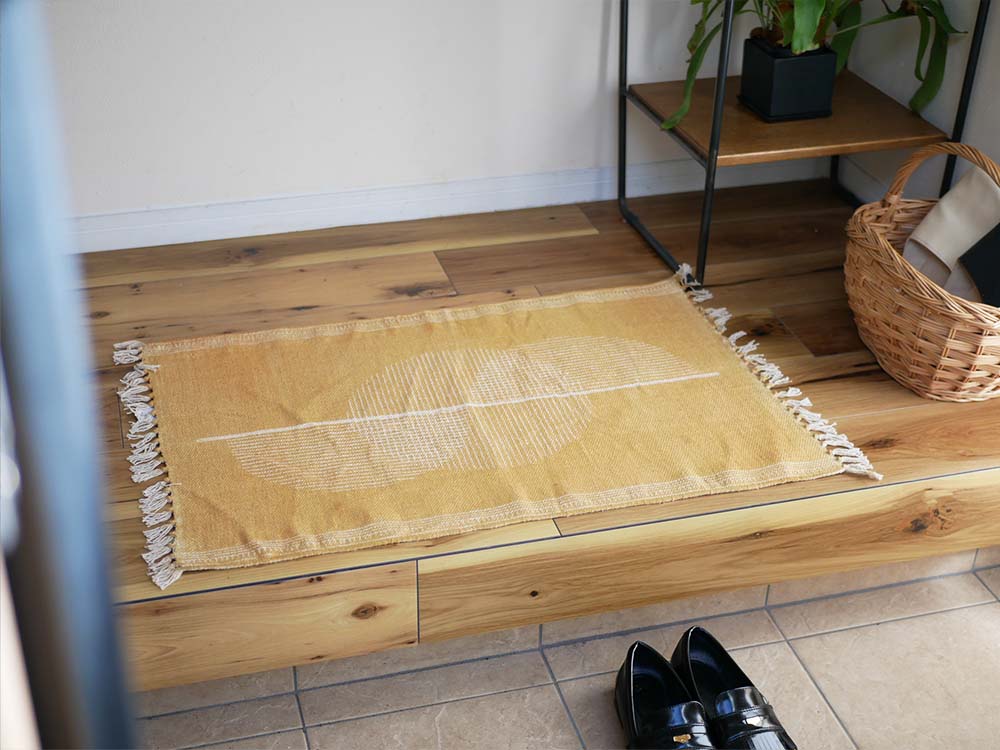 木製の床にアデペシュのコットンマットが美しく敷かれている様子