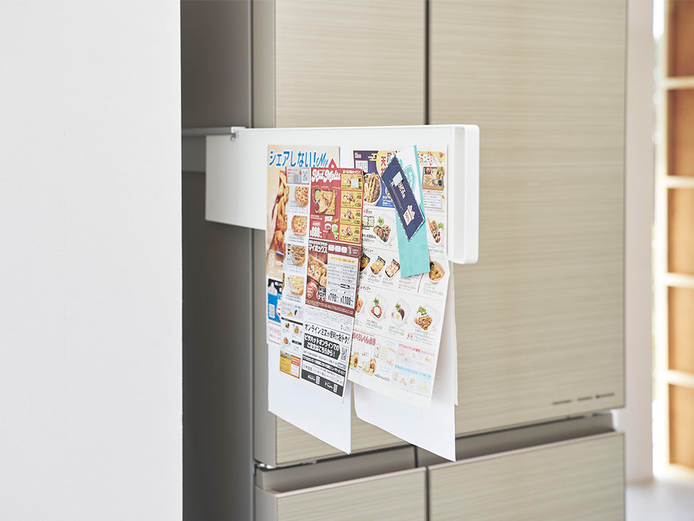 マグネットで取り付けられたスライドスチールパネルが冷蔵庫の横面に設置され、デッドスペースに物を隠している様子