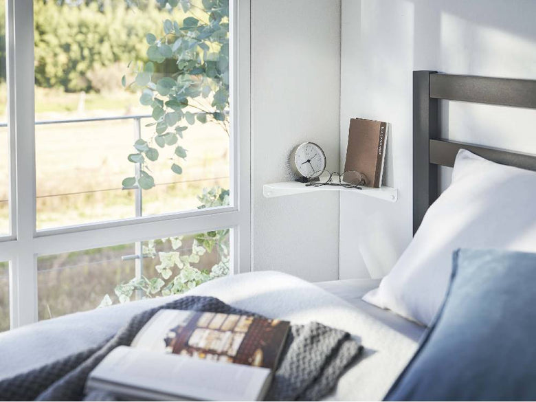 ベッドルームのインテリアに配置された【tower】石こうボード対応コーナーシェルフとベッド、寝具、家具が調和する空間