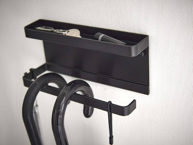 トレー付きスチール製アンブレラホルダーが石こうボードの壁に取り付けられている様子