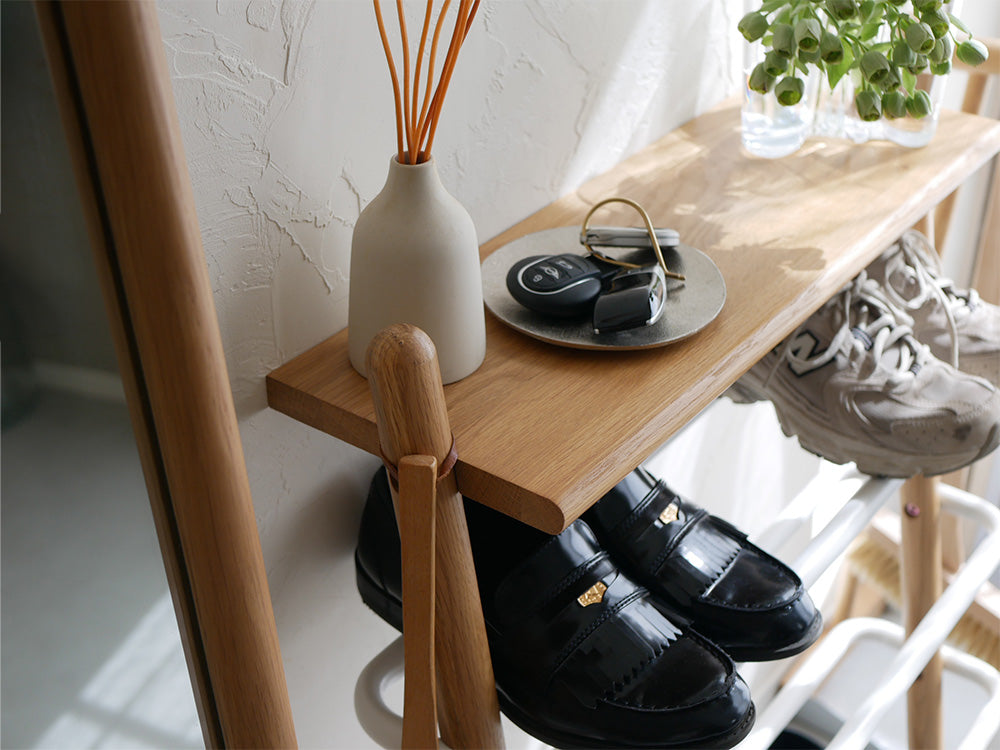 オーク無垢材とスチールで作られた立て掛け式シューズラック。複数の木製棚が配置されています