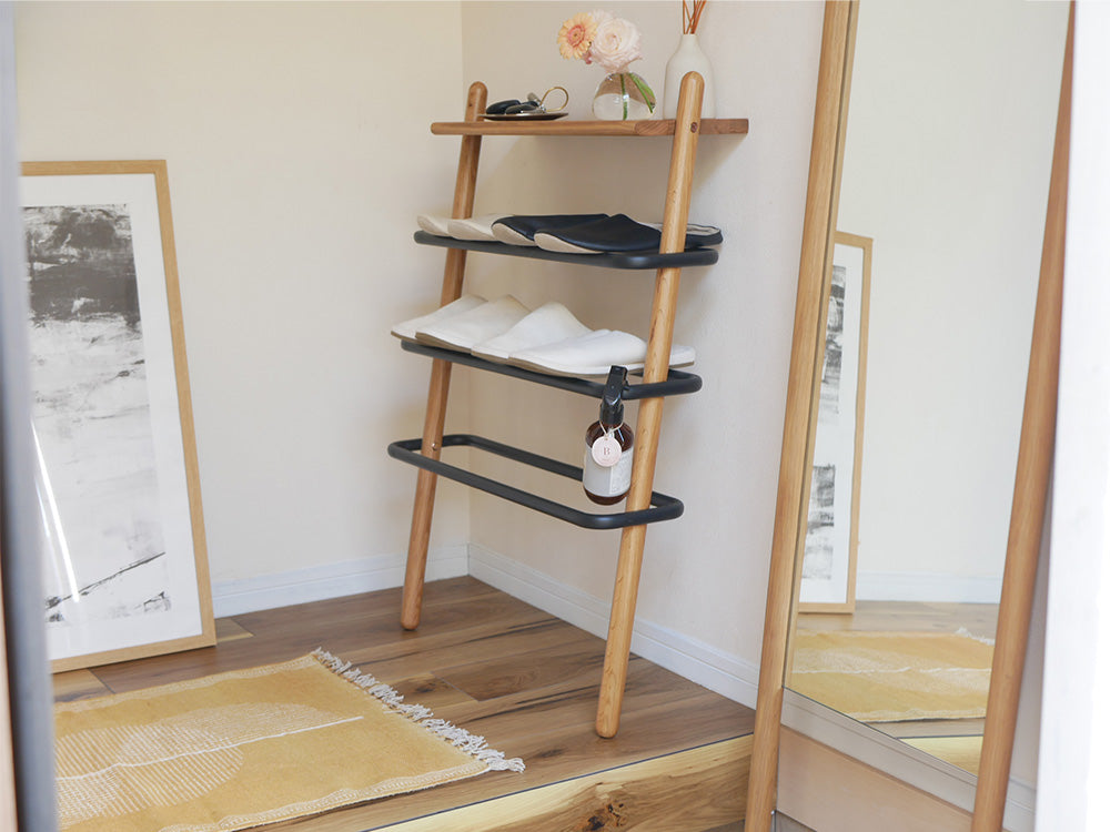 オーク無垢材とスチール製の棚やハンガーが配置された「NOWHERE LIKE HOME」SUK立て掛けシューズラック