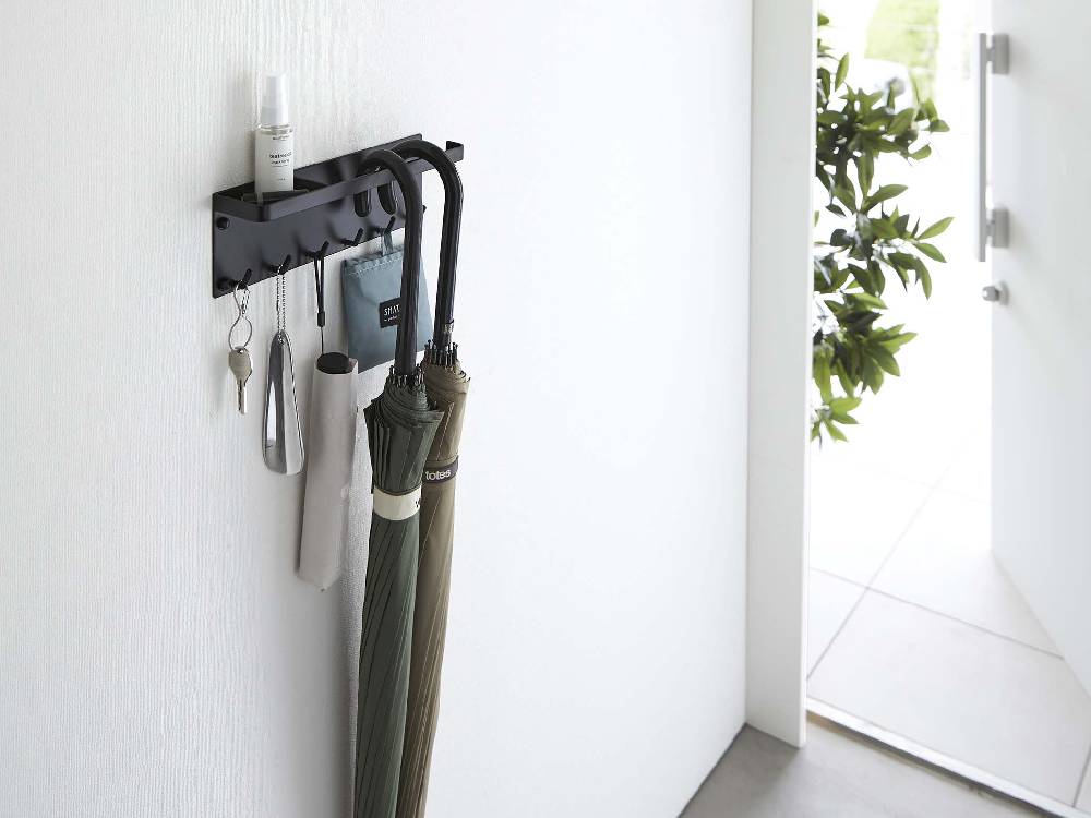 粉体塗装されたスチール製トレー付きアンブレラホルダーが石こうボードの壁面に設置されている様子