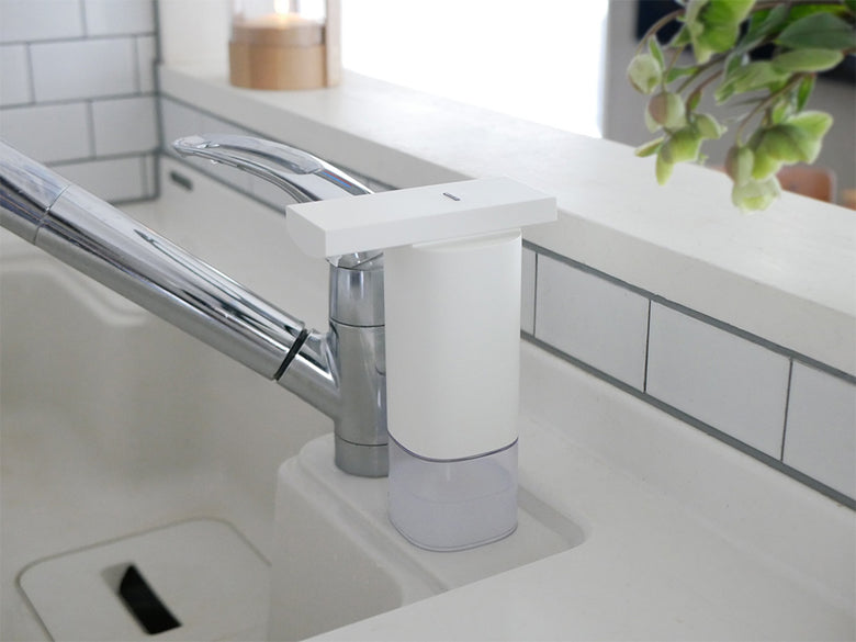 キッチンのカウンターに設置されたプラスマイナスゼロオートディスペンサーとシンク、蛇口、観葉植物が配置された様子